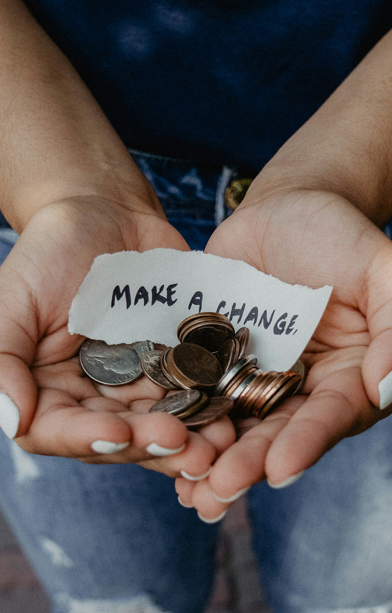 hands holding coins and paper saying "make a change"
