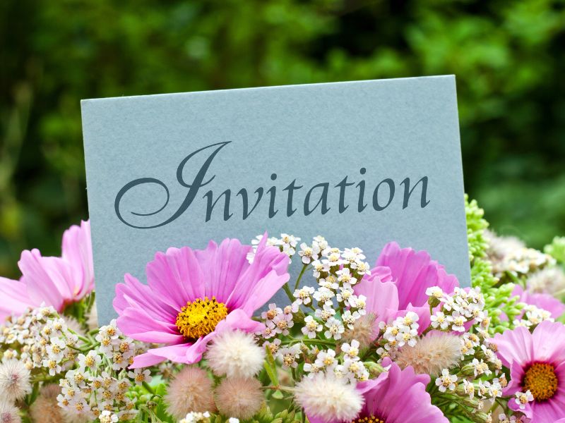 blue invitation on top of flowers