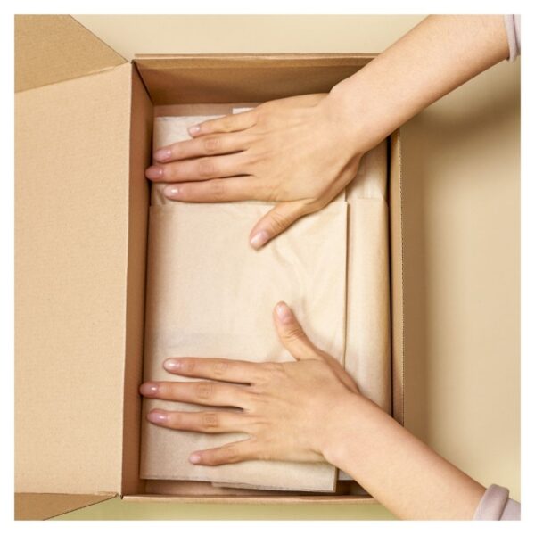 placing tissue paper in cardboard box